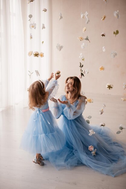 Photo mother and daughter in blue dresses