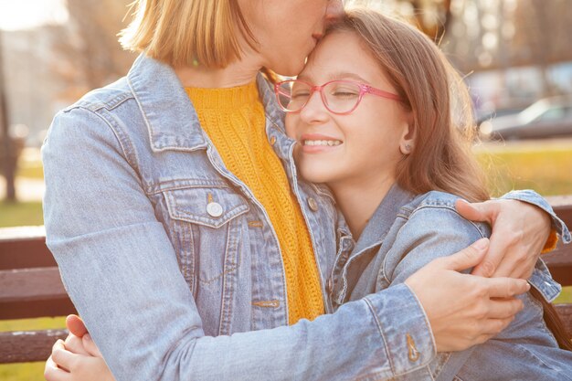 Mother and daughter at city park on a warm autumn day