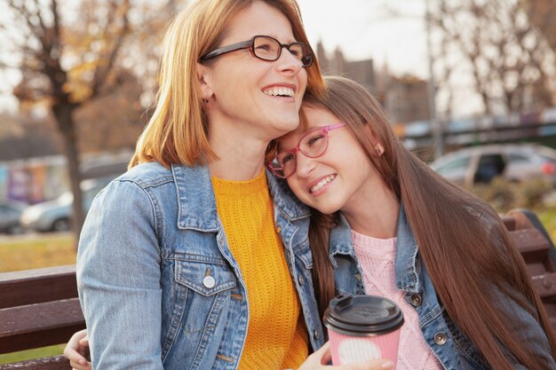 Mother and daughter at city park on a warm autumn day