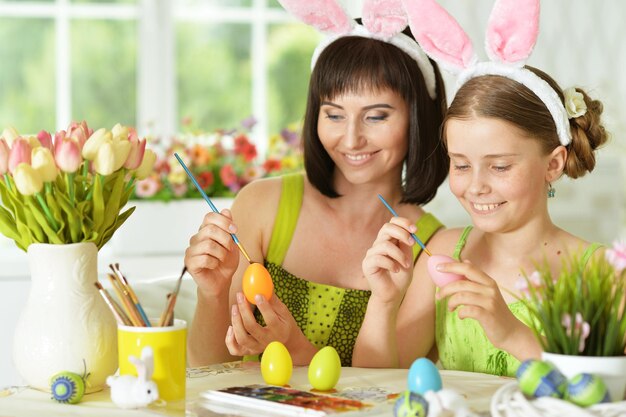 Madre e figlia che colorano le uova a pasqua