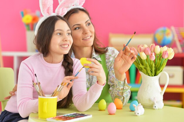 Mother and daughter colouring eggs