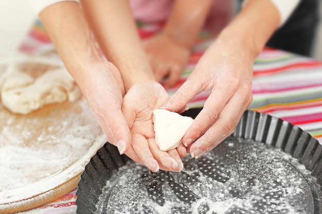 Foto madre e figlia che tagliano diverse forme di biscotti