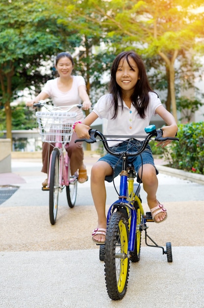 母と娘は公園で自転車をサイクリング