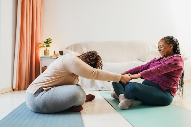 Photo mother and daughter doing fitness exercises at home together family and sport concept during winter time focus on hands