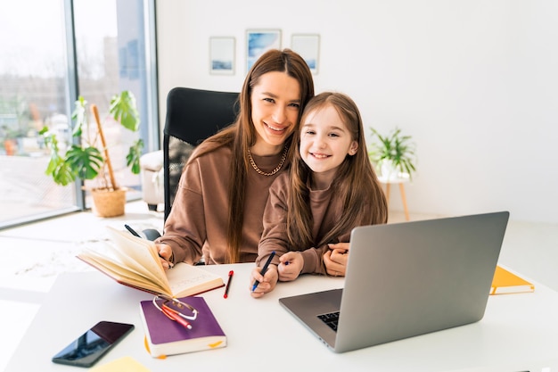 Mother and daughter doing homework at the laptop