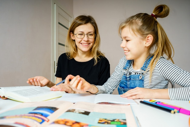 Madre e figlia a fare i compiti insieme, styding e concetto di apprendimento, facendo compiti per la scuola