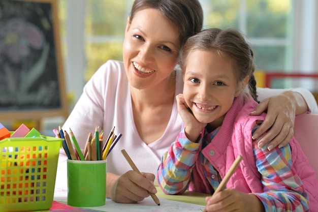 Mother and daughter drawing with pencils