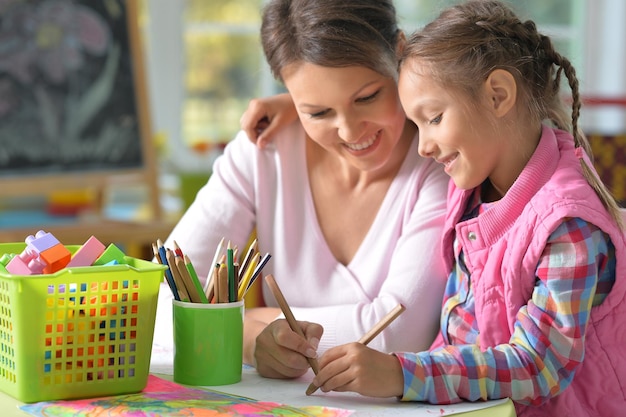 Mother and daughter drawing with pencils