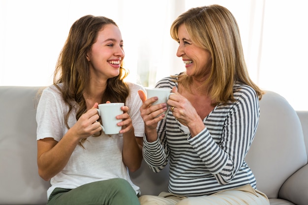 Photo mother and daughter drink tea at home