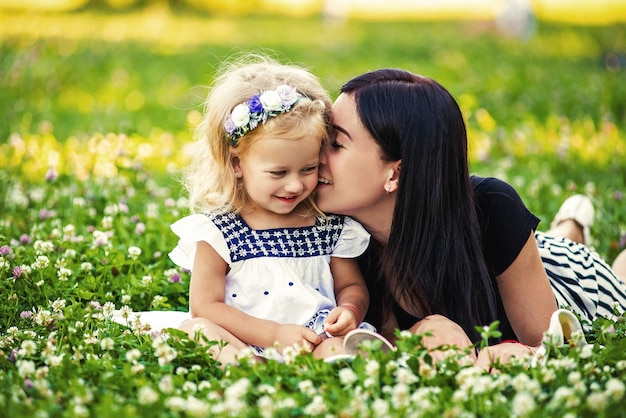 Madre e figlia che mangiano una mela in natura. madre e figlio si godono l'inizio della primavera, mangiando mele, felici.