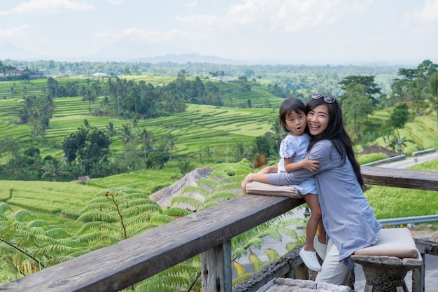 Mother and daughter enjoy paddy rice field view