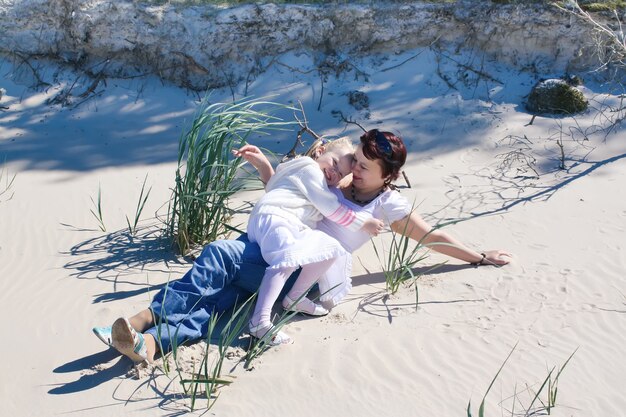 Mother and daughter enjoying time in warm spring day on the coast near the Baltic sea.