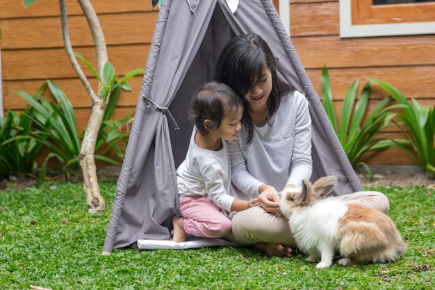 Mother and daughter feeding rabbit