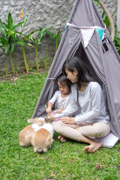 Mother and daughter feeding rabbit