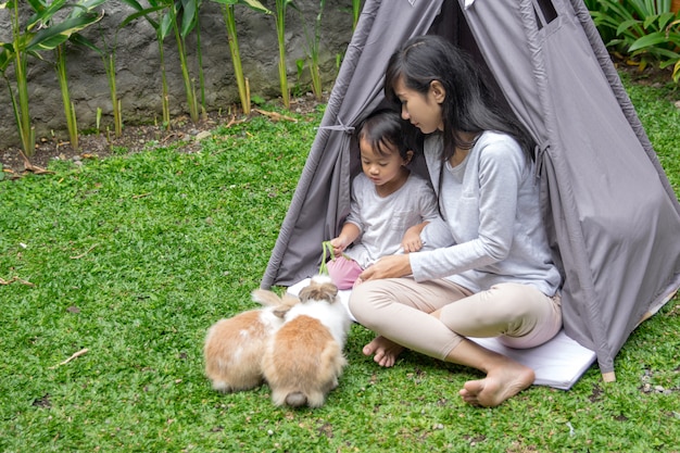 Mother and daughter feeding rabbit