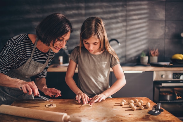 Mother and daughter filling ravioli with chocolate cream