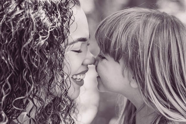 Photo mother and daughter giving eskimo kiss. mothers day. afro mother and white daughter