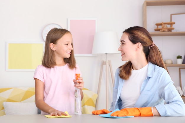 Mother and daughter in a good mood are cleaning the house