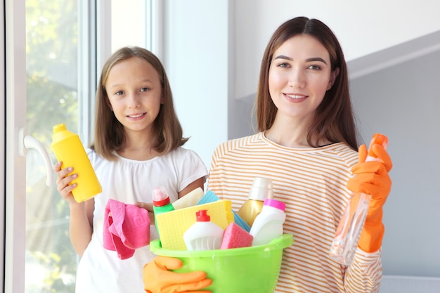 Mother and daughter in a good mood are cleaning the house