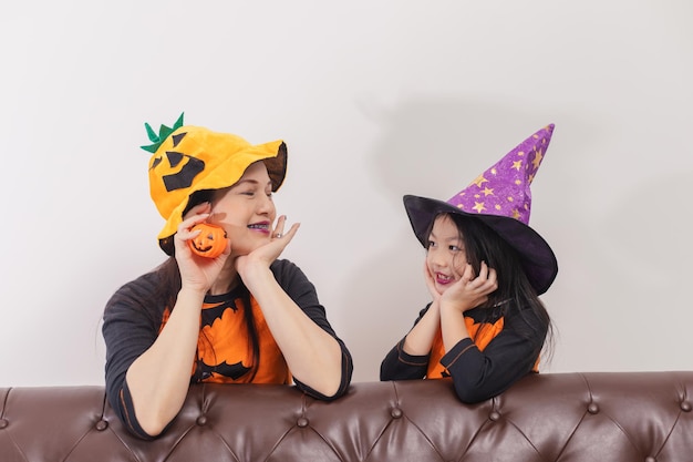 Mother and daughter in Halloween costumes having fun at home