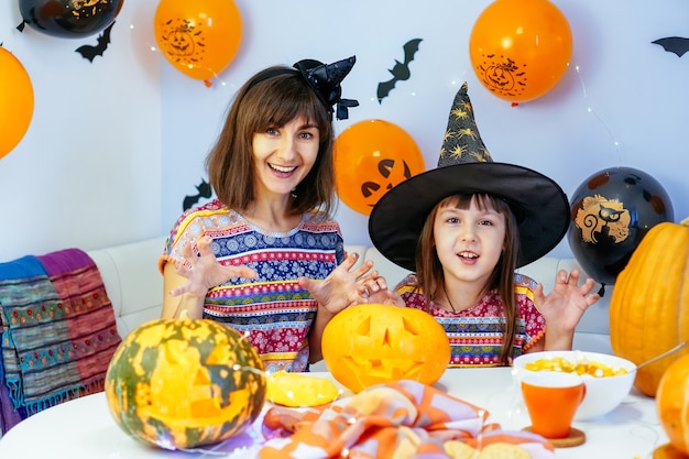 Mother and daughter have fun cleaning out insides of pumpkin to make jack o lantern for halloween