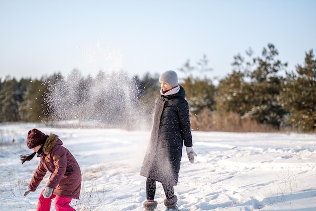 Mother and daughter have fun in the forest in winter on a day off