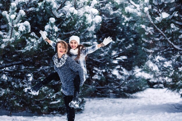 Mother and daughter have fun playing in the winter forest