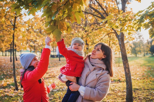 떨어지는 나뭇잎 사이 가을 공원에서 재미 엄마와 딸. 활동적인 라이프 스타일