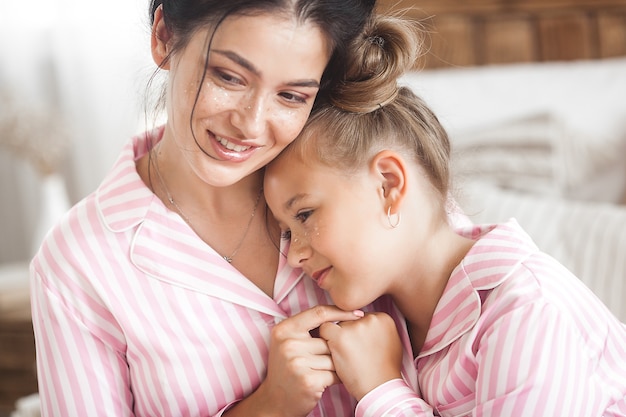 Mother and daughter having fun at home. Girls indoors.