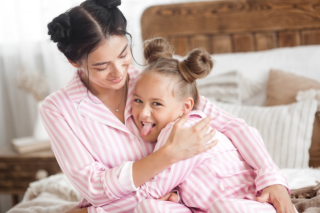 Mother and daughter having fun at home. Girls indoors.