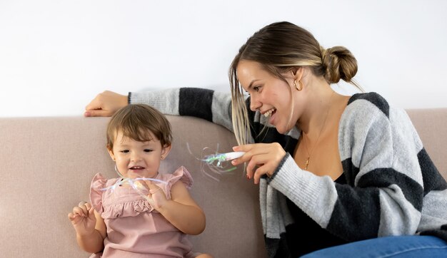 Mother and daughter having fun on the sofa