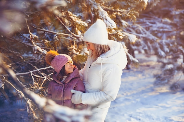 Мать и дочь веселятся в зимнем парке.