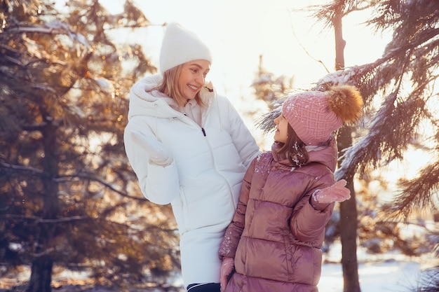 Mother and daughter having fun in the winter park