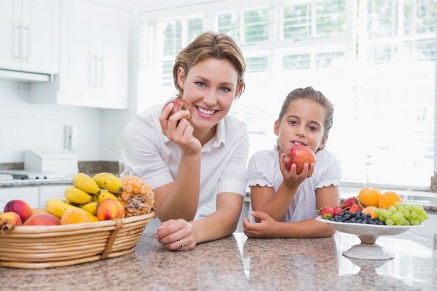 Mother and daughter holding apples