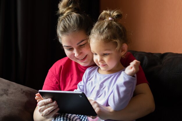 Mother and daughter at home use tablet pc