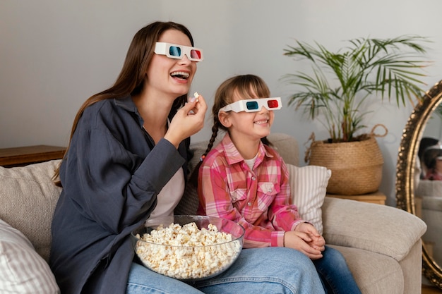 Foto madre e figlia a casa a guardare film