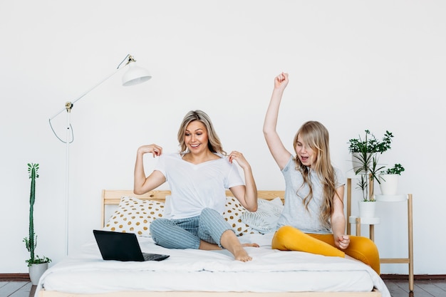 Madre e figlia a casa con il computer portatile