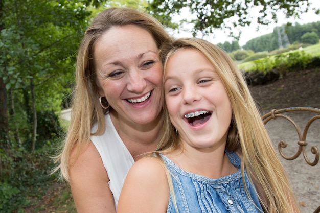 Mother and daughter hugging in love playing in the park