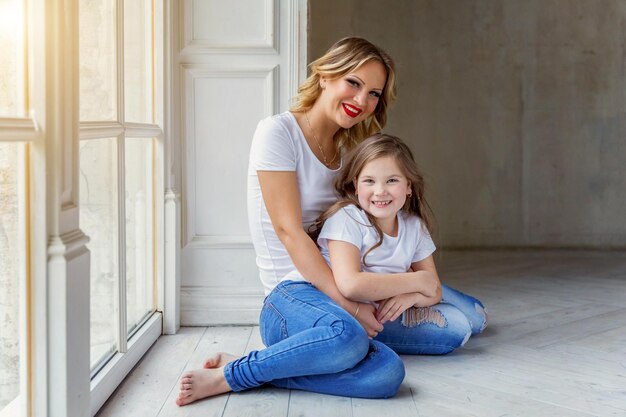 Mother and daughter hugging near windiow