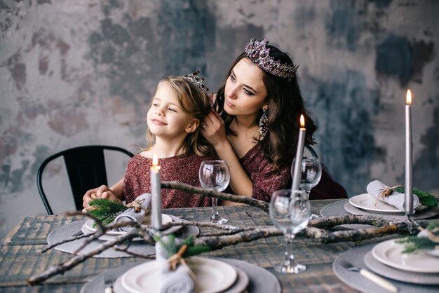 Mother and daughter in the image of the queen and princess dresses in the colors of Marsala the Christmas table