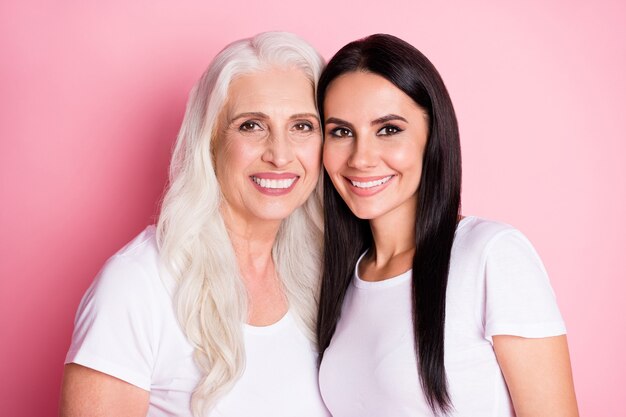 mother and daughter isolated on pink