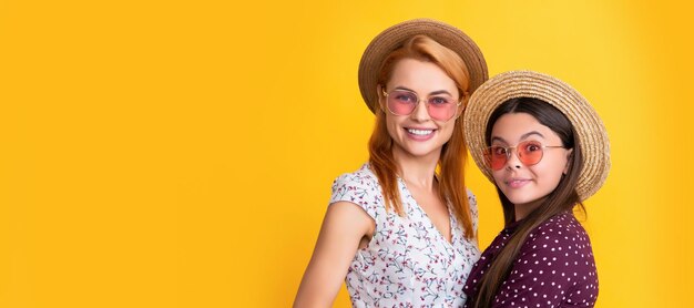 Mother and daughter kid banner copy space isolated background smiling mother and child in straw hat on yellow background