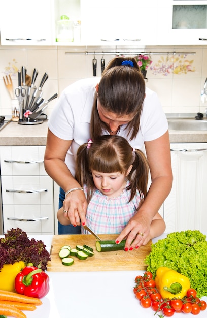 Mother and daughter in kitchen preparing vegetables