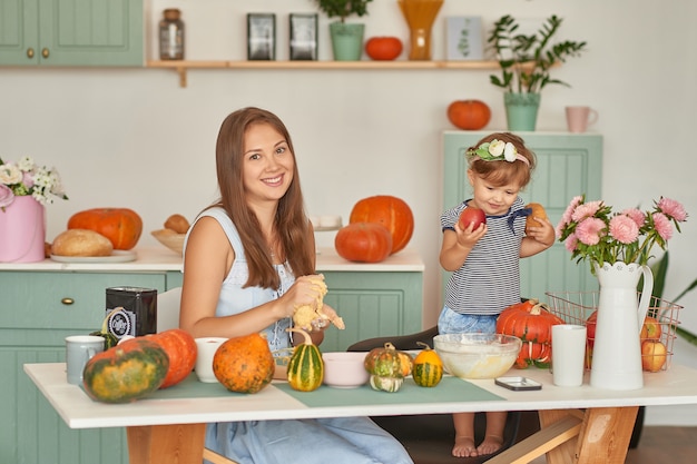 Mother and daughter in the kitchen with Thanksgiving decorations