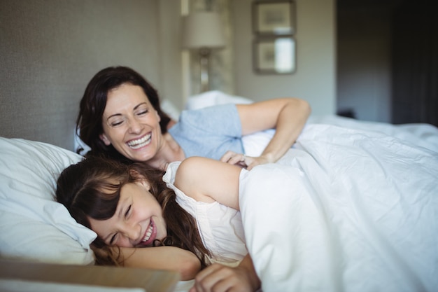 Мать и дочь смеются в постели