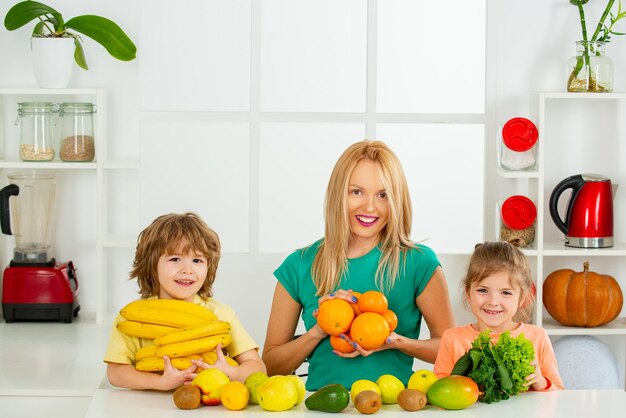 Mother daughter and little son preparing healthy smoothie in the modern kitchen healthy kids food