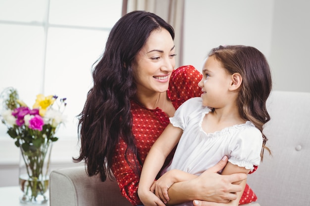 Mother and daughter looking at each other at home 