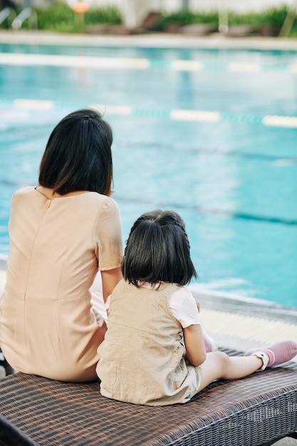 Mother and daughter looking at swimming pool