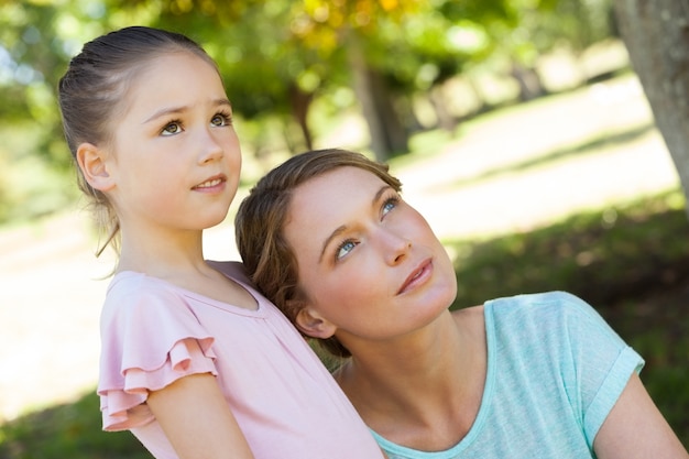 Mother and daughter looking up at park