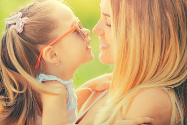 Photo mother and daughter in love. happy family girls hugging and kissing.